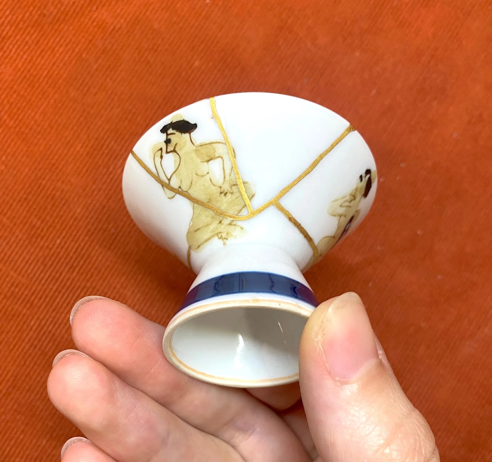 金継ぎで直された盃（さかずき）を手に持つ様子